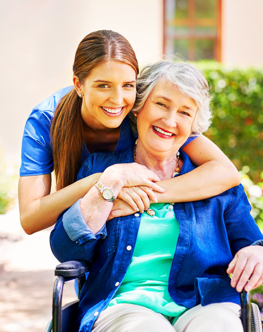 aide hugging an elderly woman